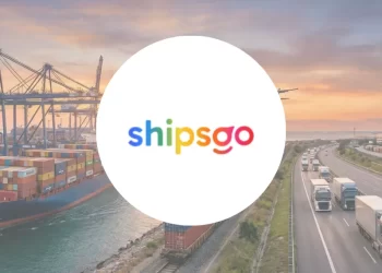 Dünya haritası ve lojistik rotaları arka planı üzerinde beyaz daire içinde ShipsGo logosu