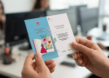 8 Mart Dünya Kadınlar Günü için çalışanlara sunulan, modern ofis ortamında bir kadının elinde tuttuğu anlamlı bağış sertifikası hediyesi.